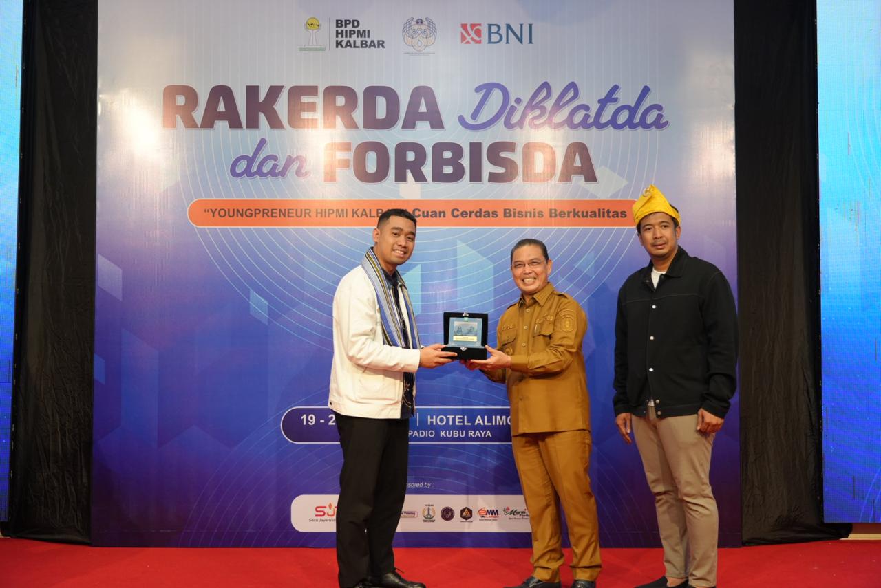 Ketua BPD HIPMI Kalbar, Aditya Setiawan menyerahkan cenderamata kepada Gubernur Kalbar, Ria Norsan saat membuka Rapat Kerja Daerah (Rakerda), Diklatda, dan Forum Bisnis Daerah (Forbisda) HIPMI Kalbar 2026, Selasa (19/4/2026). Foto: Istimewa