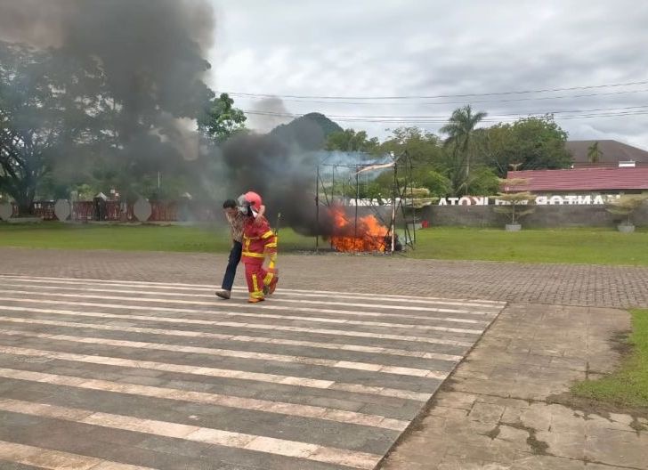 Petugas pemadam kebakaran Singkawang mengevakuasi warga dari kobaran api saat simulasi peristiwa kebakaran sebagai bagian darurat SIGAP 112 yang digelar di Halaman Kantor Wali Kota Singkawang, Senin (18/5/2026). Foto: Istimewa