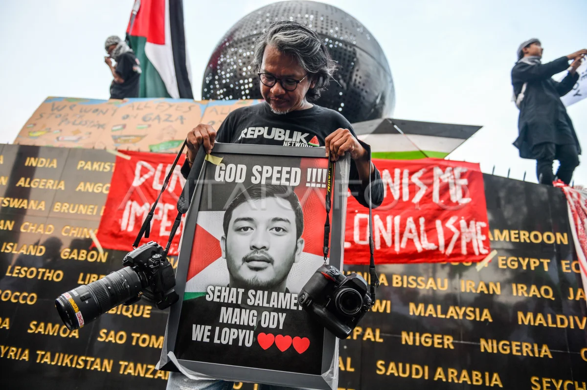 Pewarta foto senior, Yogi Ardhi memegang foto Pewarta Foto Republika Thoudy Badai salah satu jurnalis yang diculik Israel saat mengikuti aksi solidaritas bagi WNI dan Jurnalis di Jalan Asia Afrika, Bandung, Jawa Barat, Selasa (19/5/2026). Foto: ANTARA