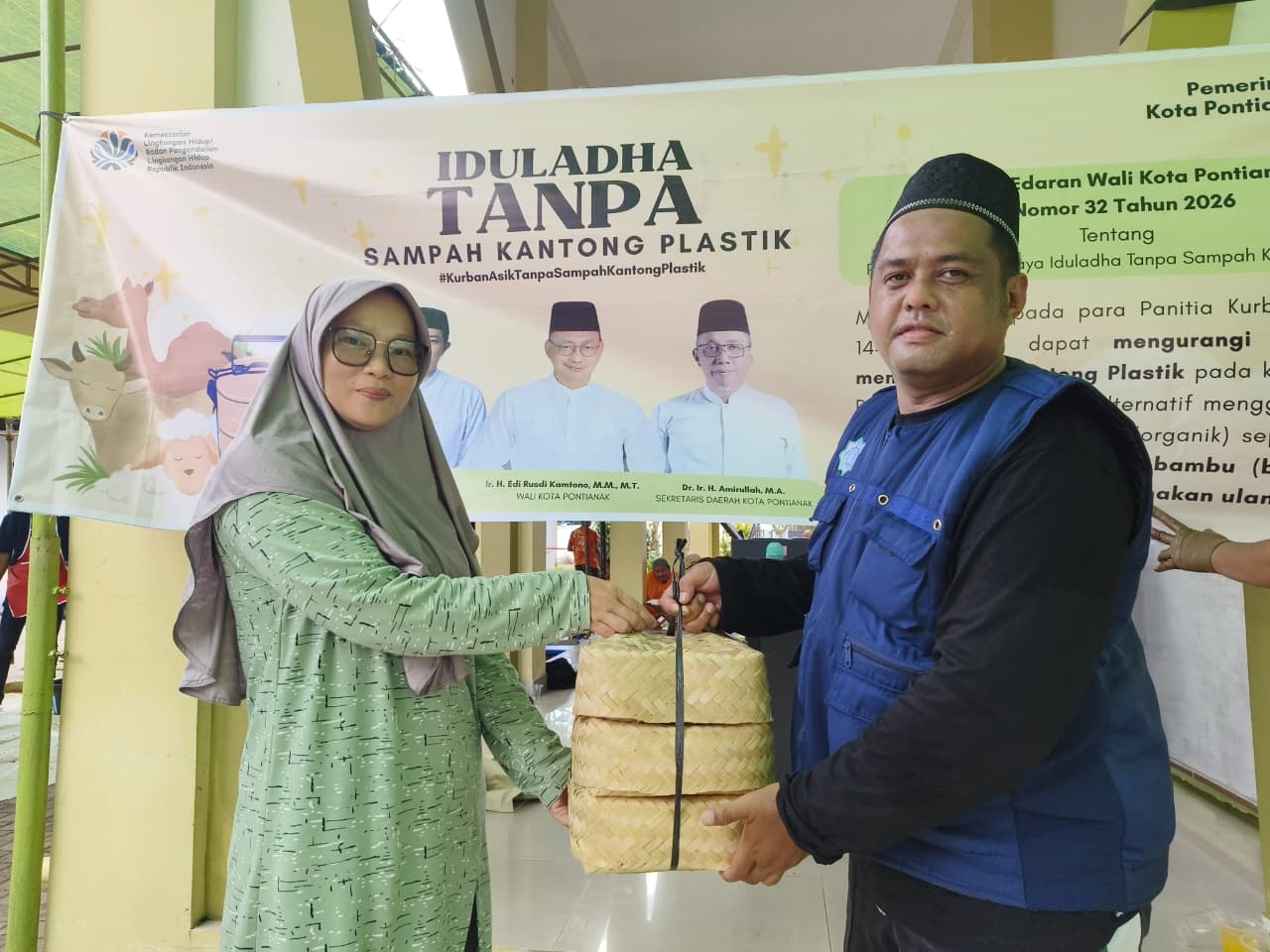 Ketua Panitia Kurban Masjid Al-Ikhlas, Aan secara simbolis menerima besek bambu atau wadah guna ulang dari perwakilan DLH Pontianak untuk penyaluran kurban pada Iduladha 1447 Hijriah. Foto: Istimewa