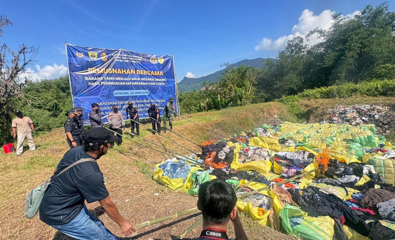 Petugas Bea Cukai bersama unsur TNI, Polri, dan instansi terkait memusnahkan Barang Milik Negara (BMN) hasil penindakan kepabeanan dan cukai di KPPBC TMP C Entikong, Kabupaten Sanggau, Selasa (24/6). Foto: Istimewa.