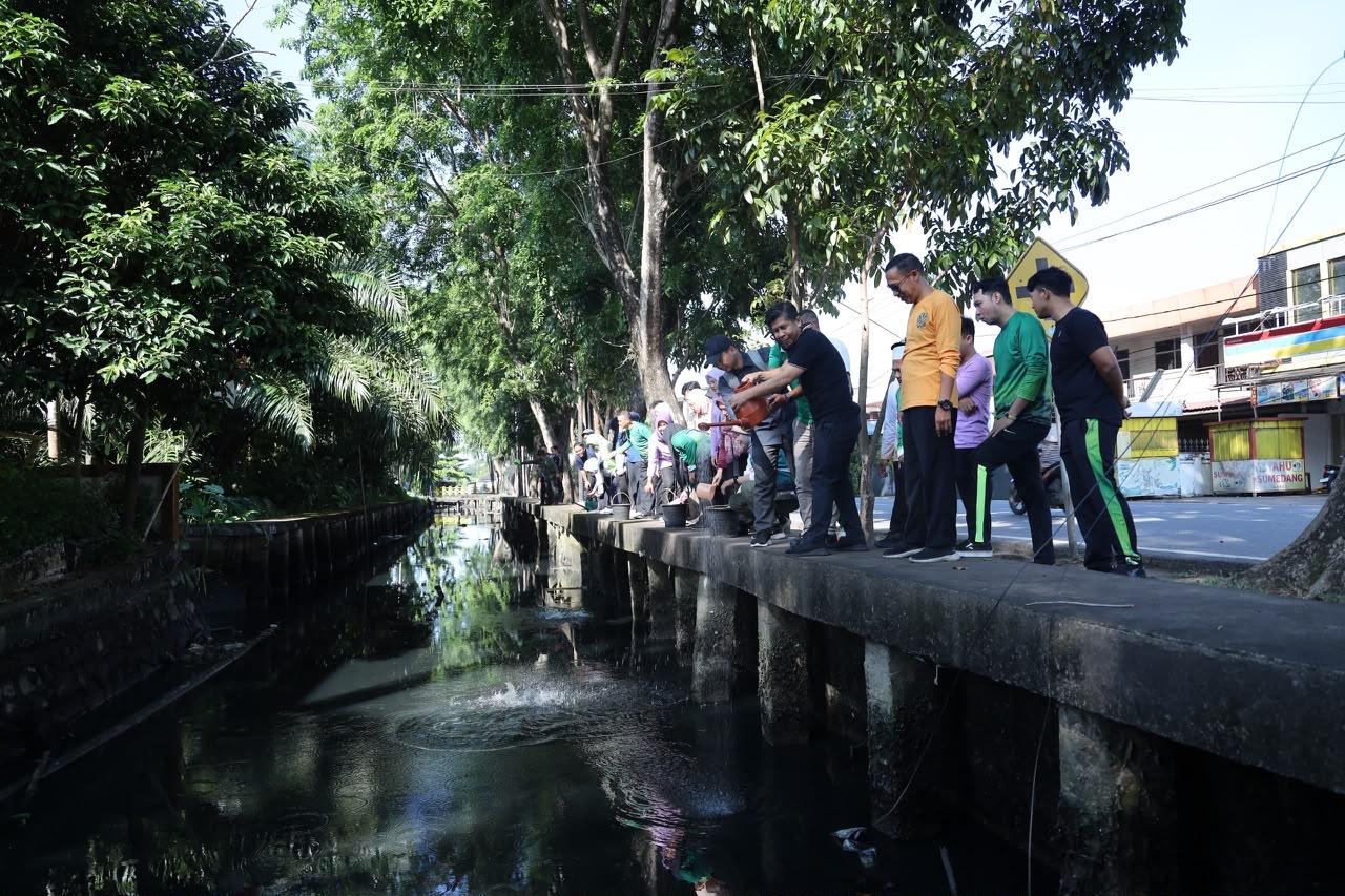 Dinas Lingkungan Hidup (DLH) Kota Pontianak menaburkan eco enzym di saluran parit kawasan Kantor DLH, Jalan Alianyang, Jumat (5/6/2026). Upaya ini dilakukan untuk membantu meningkatkan kualitas air sekaligus mengurangi bau tidak sedap di saluran drainase. Foto: Istimewa