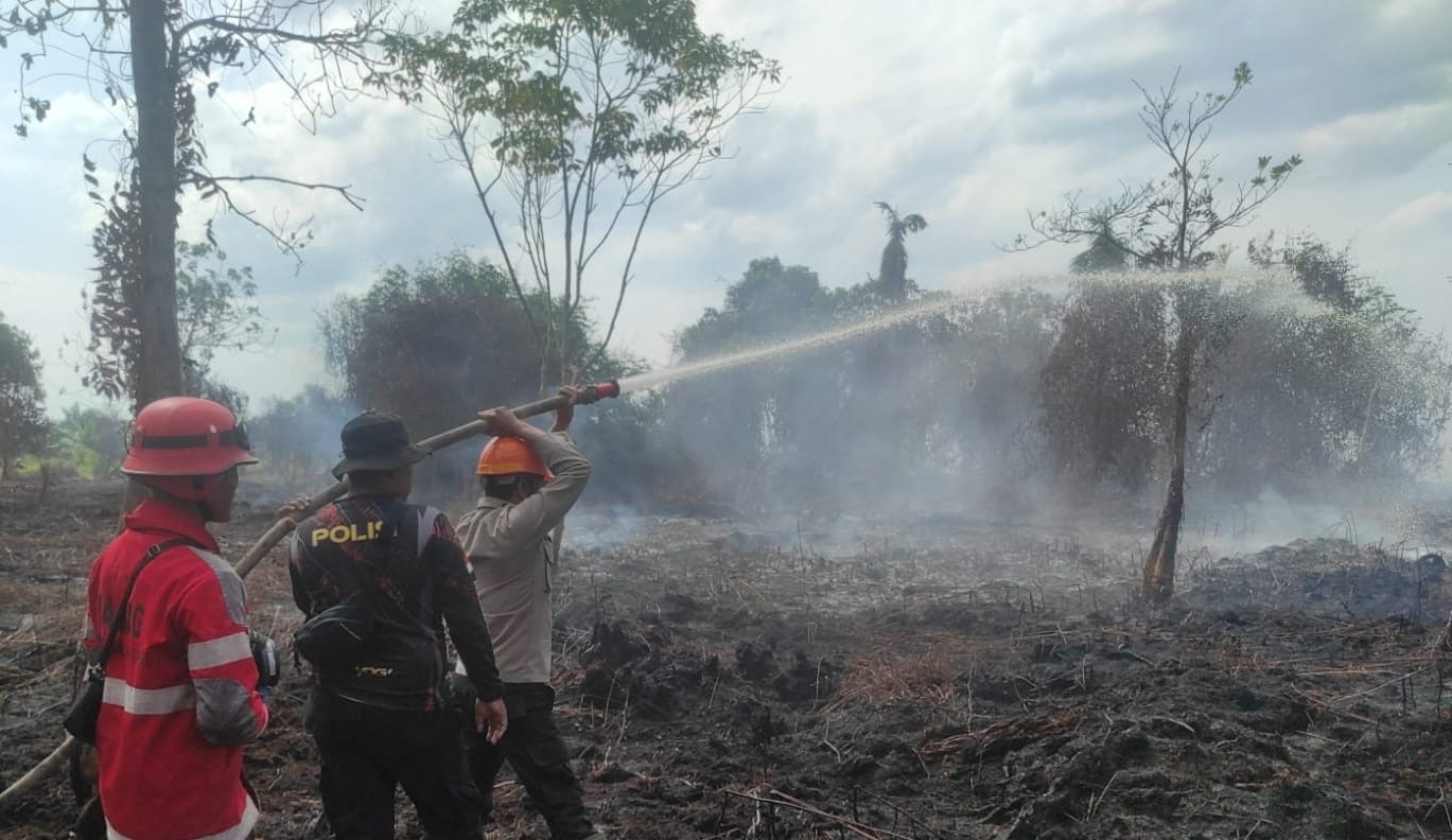 Personel Polsek Rasau Jaya bersama tim gabungan memadamkan kebakaran lahan gambut di Kabupaten Kubu Raya. Pendinginan terus dilakukan guna mengantisipasi api muncul kembali dari bawah permukaan tanah. Foto: Istimewa
