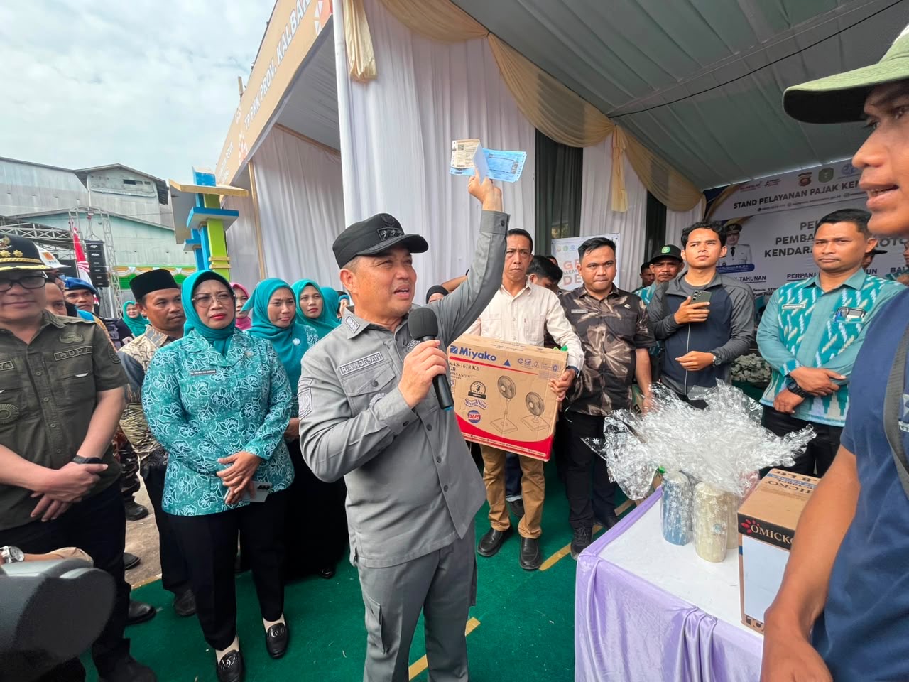 Gubernur Kalimantan Barat Ria Norsan menunjukkan bukti pembayaran pajak kendaraan usai meninjau layanan perpanjangan pajak tahunan STNK dalam Program Gema Membangun Desa di Kecamatan Teluk Batang, Kabupaten Kayong Utara, Jumat (31/7/2026). Foto: Istimewa