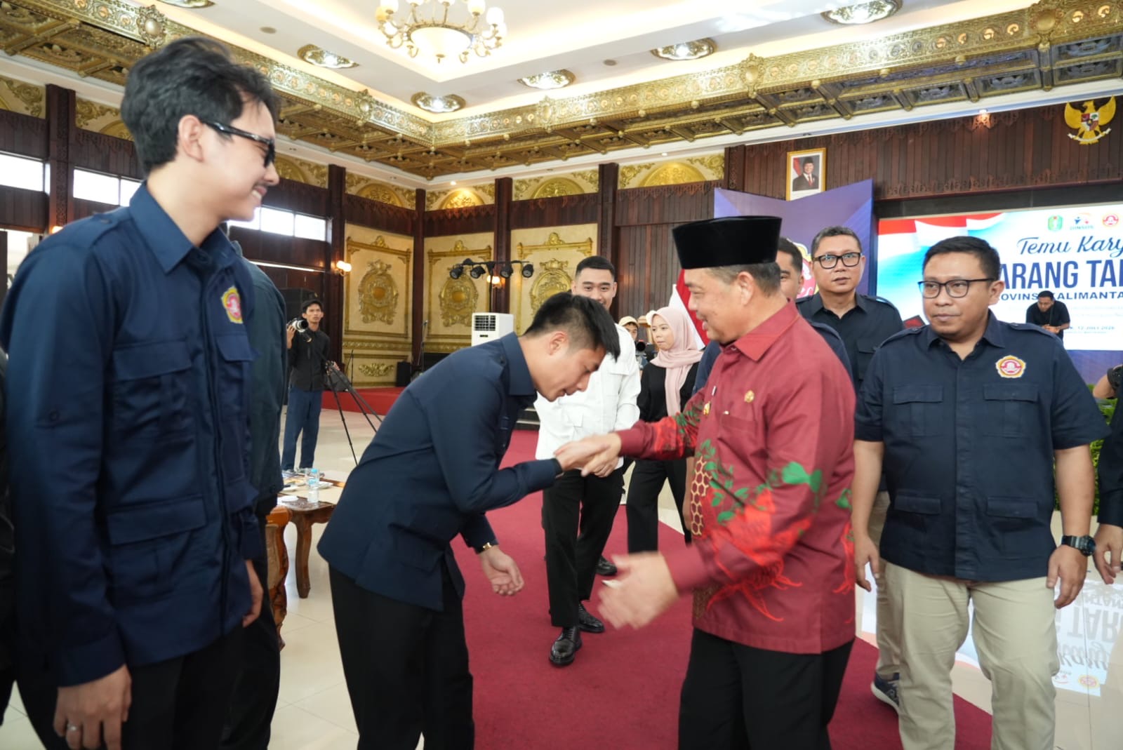 Ketua Karang Taruna Kalbar terpilih, Muhammad Farizi, mencium tangan Gubernur Kalbar Ria Norsan usai pembukaan Temu Karya Karang Taruna Kalbar di Pendopo Gubernur, Pontianak, Minggu (12/7/2026). Foto: Istimewa