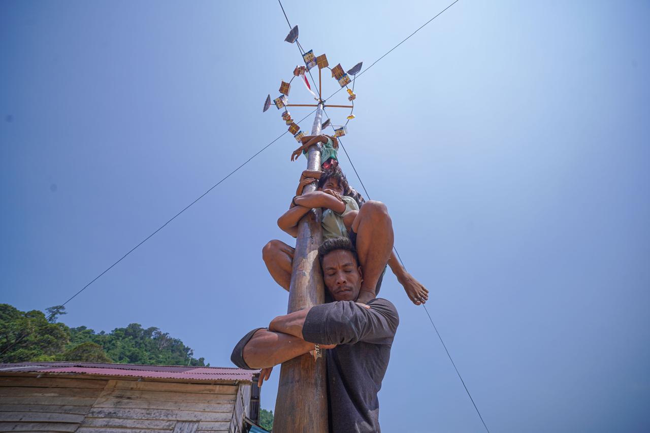 Warga bergotong royong menaklukkan tantangan panjat pinang sebagai salah satu perlombaan dalam rangkaian perayaan HUT ke-81 RI di Desa Pelapis, Kecamatan Kepulauan Karimata, Kabupaten Kayong Utara. Foto: Istimewa
