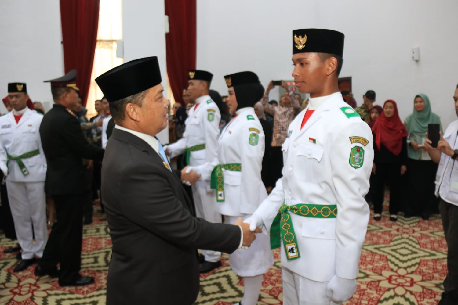 Gubernur Kalbar Ria Norsan menyalami anggota Paskibraka Kalbar 2026 usai pengukuhan di Balai Petitih Kantor Gubernur Kalbar, Sabtu (15/8/2026). Paskibraka akan bertugas mengibarkan Merah Putih pada upacara HUT ke-81 RI, Senin (17/8/2026). Foto: Istimewa