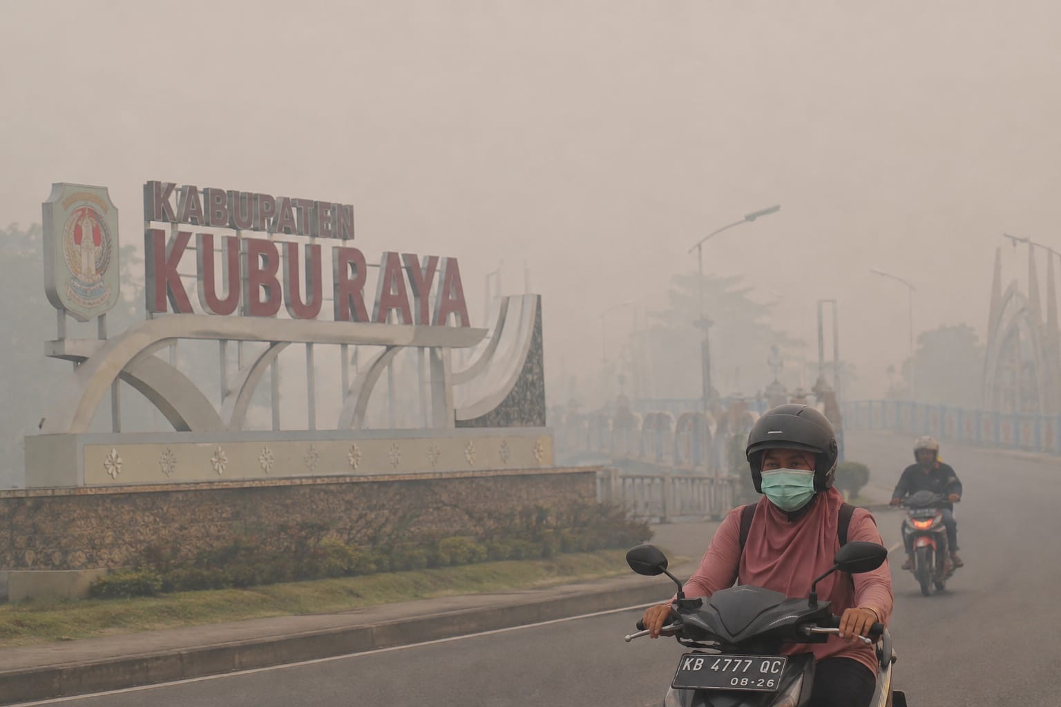 Kabut asap menyelimuti kawasan Kabupaten Kubu Raya, Kalimantan Barat. Pengendara sepeda motor tetap melintas di tengah jarak pandang yang terbatas akibat pekatnya asap. Kalimantan Barat menjadi salah satu dari enam provinsi yang mendapat perhatian khusus pemerintah dalam penanganan kebakaran hutan dan lahan (karhutla). Foto: Istimewa