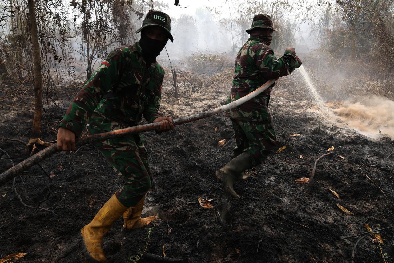 Personel Yonif TP 882/Hulubalang melakukan pembasahan untuk mencegah api kembali menyala di lokasi kebakaran lahan gambut di Desa Arang Limbung, Kecamatan Sungai Raya, Kabupaten Kubu Raya, Minggu (23/8/2026). ANTARA