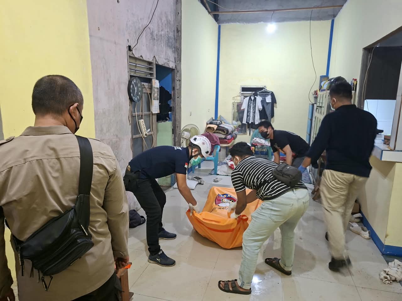 Petugas Polsek Sungai Ambawang mengevakuasi jenazah Tİ (58) yang ditemukan meninggal dunia di kamar rumahnya di Desa Mega Timur, Kecamatan Sungai Ambawang, Kabupaten Kubu Raya, Jumat (25/9/2026) sore. Foto: Istimewa