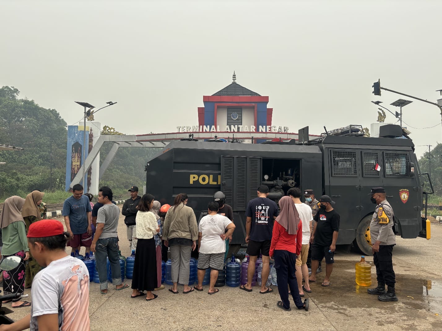 Warga mengantre mengambil air bersih yang disalurkan Polres Kubu Raya menggunakan Water Cannon di kawasan Terminal Tipe A BPTD Kelas II Sungai Ambawang, Minggu (6/9/2026). Sebanyak 6.000 liter air bersih dibagikan untuk membantu warga yang terdampak keterbatasan air akibat kemarau. Foto: Istimewa