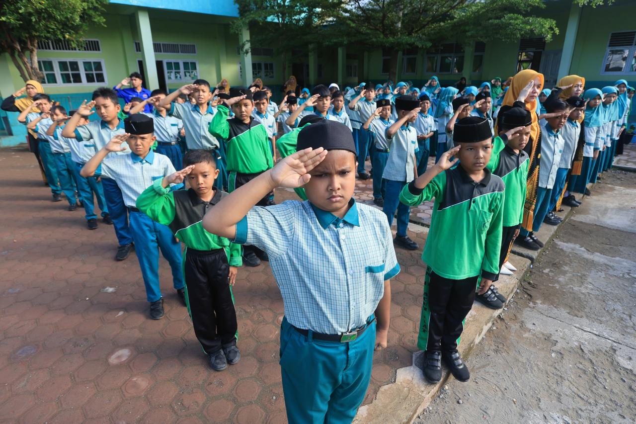 Siswa dan dewan guru memberikan penghormatan saat pengibaran bendera Merah Putih pada upacara peringatan Hari Kesaktian Pancasila di Madrasah Ibtidaiyah Negeri (MIN) 11 Aceh Barat dan Madrasah Tsanawiyah Swasta (MTsS) Harapan Bangsa Desa Kuta Padang, Johan Pahlawan, Aceh Barat, Aceh, Kamis (1/10/2026). ANTARA
