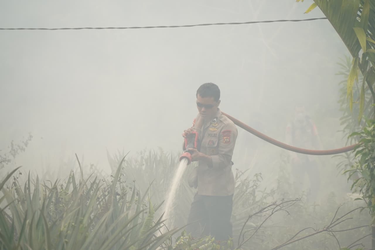 Petugas berjibaku memadamkan kebakaran hutan dan lahan (karhutla) di tengah kepungan asap. Foto: Akcaya