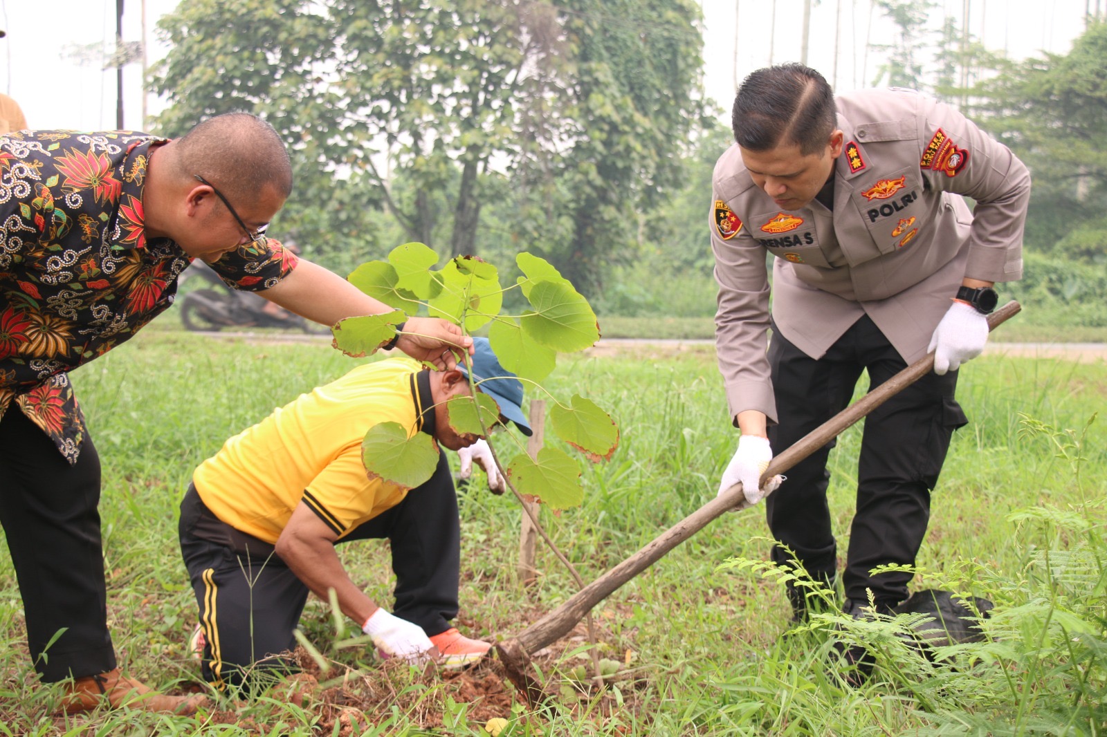 Kapolres Kubu Raya AKBP Rensa S. Aktadivia bersama Kasubsi Penmas Polres Kubu Raya Aiptu Ade menanam bibit pohon di Jalan Poros Desa Durian, Kecamatan Sungai Ambawang, Jumat (23/10/2026), dalam kegiatan Green Policing. Foto: Istimewa